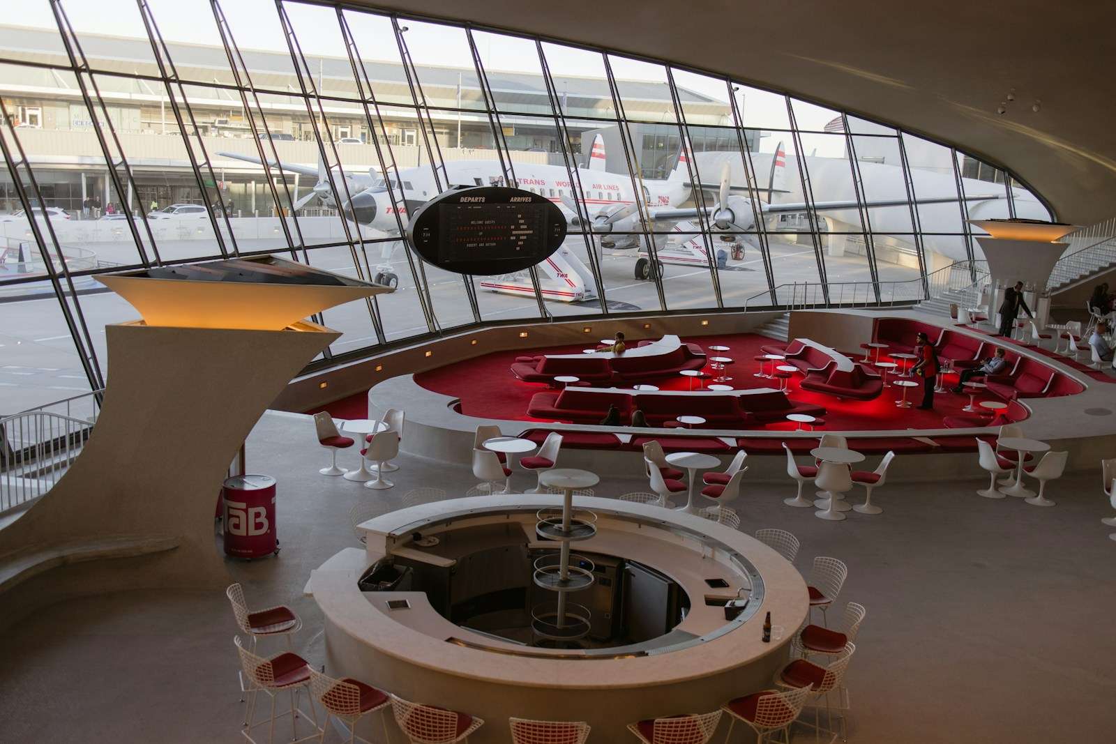 a large room with a red table and red chairs